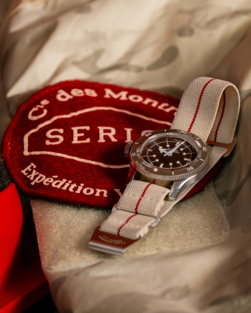 Vidéo produit : montre Serica sur son bracelet, près d’un écusson d’expédition